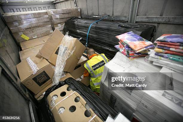 Border Force staff check inside the back of a lorry as it arrives at the UK border after leaving a cross-channel ferry on August 13, 2014 in...