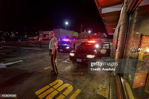 Police provides the security as demonstrators stage a rally on West Florissant Avenue to protest the shooting death of an unarmed teen by a police...