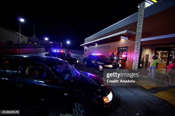 Demonstrators take part in a rally on West Florissant Avenue to protest the shooting death of an unarmed teen by a police officer in Ferguson,...