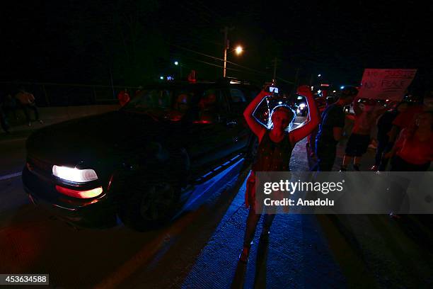 Demonstrators raise their hands during a rally on West Florissant Avenue to protest the shooting death of an unarmed teen by a police officer in...