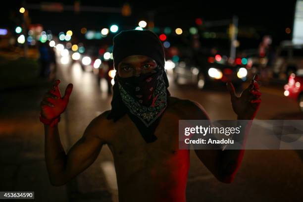 Demonstrator raises his hands during a rally on West Florissant Avenue to protest the shooting death of an unarmed teen by a police officer in...