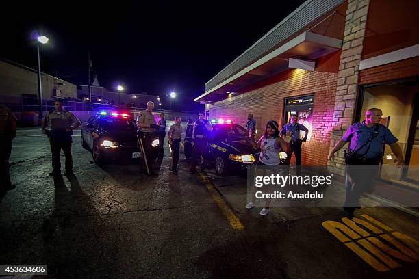 Demonstrator raises her hands next to police during a rally on West Florissant Avenue to protest the shooting death of an unarmed teen by a police...