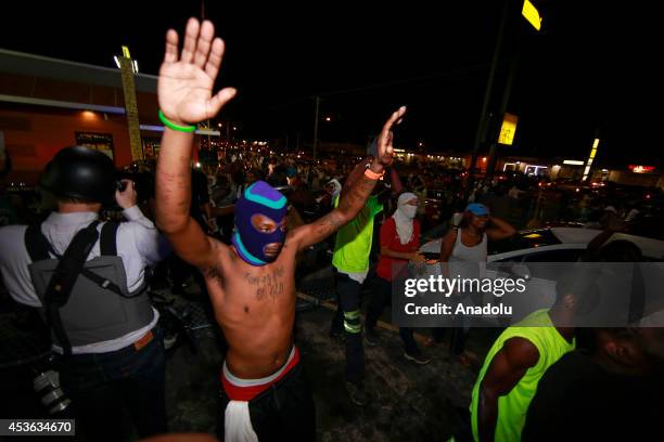 Demonstrators raise their hands during a rally on West Florissant Avenue to protest the shooting death of an unarmed teen by a police officer in...