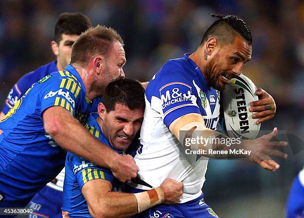 Reni Maitua of the Bulldogs is tackled by David Gower and Isaac De Gois of the Eels during the round 23 NRL match between the Parramatta Eels and the...