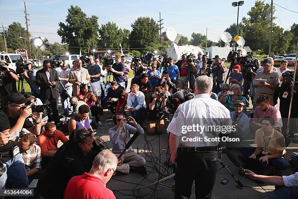 Standing in the parking lot of a gas station which was burned during rioting, Ferguson Police Chief Thomas Jackson announces the name of the Ferguson...