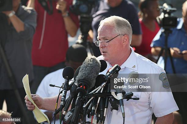 Standing in the parking lot of a gas station which was burned during rioting, Ferguson Police Chief Thomas Jackson announces the name of the Ferguson...