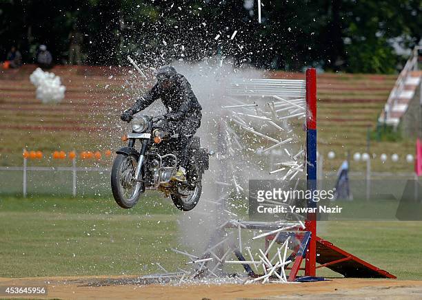 Daredevil of Indian police from Jammu and Kashmir Police wing performs stunt on his motorcycle during India's Independence Day celebrations on August...