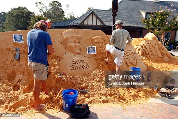 Workers construct a sand sculpture outside the clubhouse during the second round of the Wyndham Championship at Sedgefield Country Club on August 15,...