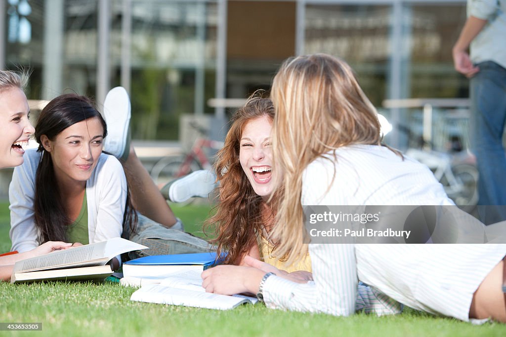グループの若い女性に楽しく芝生に書籍