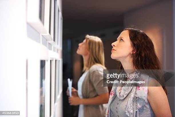 closely examining the elements of a painting - more than fair exhibition stockfoto's en -beelden