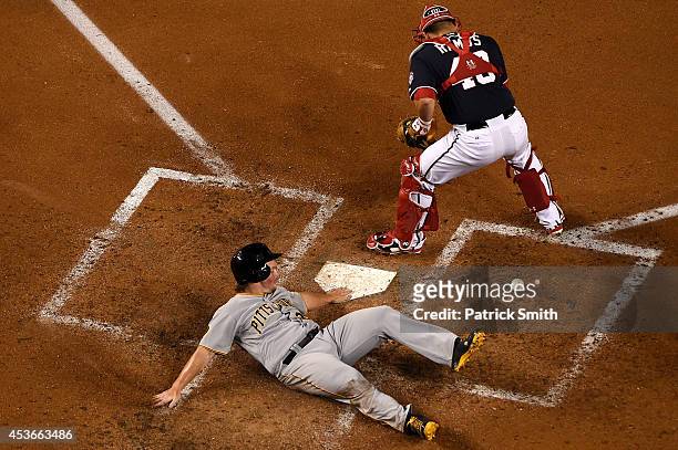 Travis Snider of the Pittsburgh Pirates scores as catcher Wilson Ramos of the Washington Nationals cannot handle the throw in the fourth inning at...