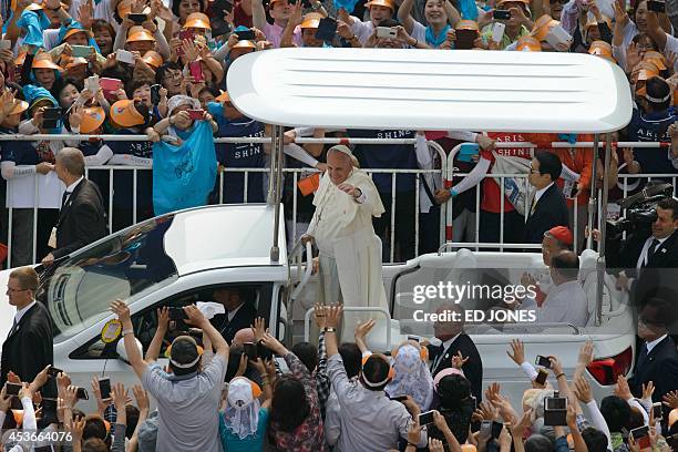 Pope Francis waves to Catholic worshippers as he arrives to lead a mass at Gwanghwamun Square in central Seoul on August 16, 2014. A tight security...