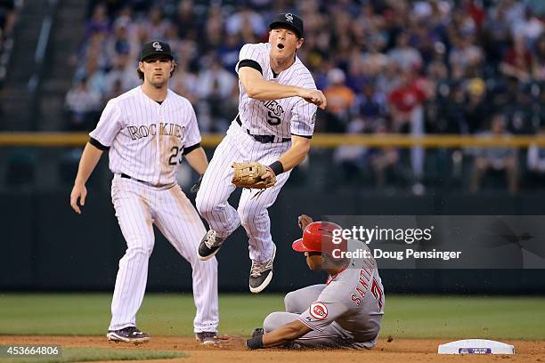 Second baseman DJ LeMahieu of the Colorado Rockies gets a force out on Ramon Santiago of the Cincinnati Reds but is unable to turn the double play on...