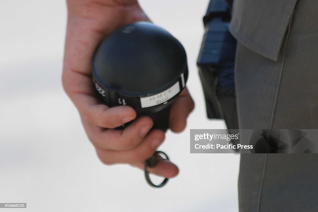 An extreme close-up of a tear gas bomb being held by an...