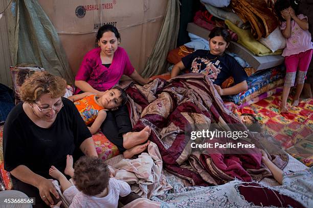 Families rest inside the Mar Tshmony church. 500 Christian families have been sheltered at Mar Tshmony church, after an unprecedented ISIS advance...