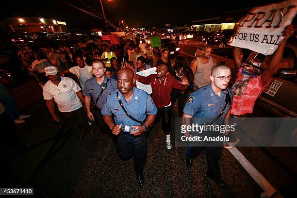 Capt. Ronald Johnson of the Missouri State Highway Patrol, walks on West Florissant Avenue where demonstrators gather to protest the shooting death...