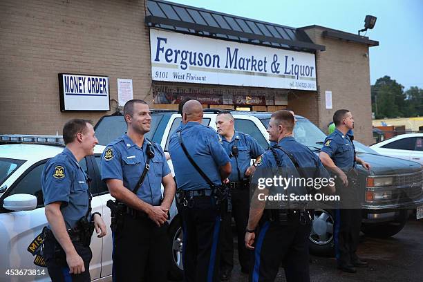 Officers with the Missouri Highway Patrol stand guard in front of the Ferguson Market and Liquor store on August 15, 2014 in Ferguson, Missouri....