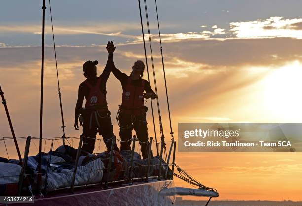 Bowman Sara Hastreiter and Sophie Ciszek high five as Team SCA's Volvo Ocean 65 skippered by Sam Davies finishes at dawn, beating the all female...