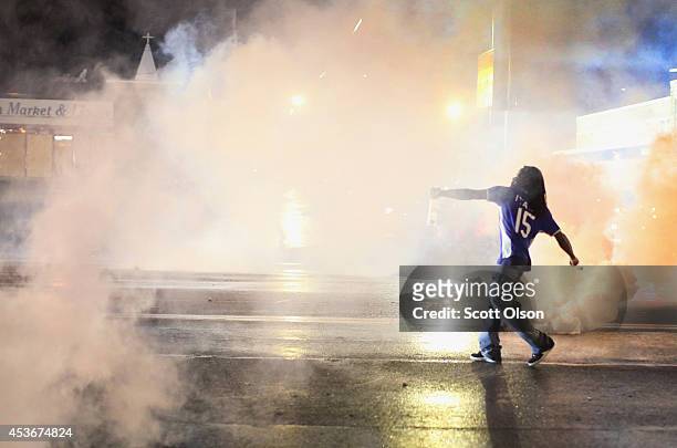 Demonstrator throws a grenade back at police after a brief clash on August 15, 2014 in Ferguson, Missouri. Police sprayed pepper spray, shot smoke,...