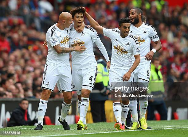 Ki Sung-Yeung of Swansea City celebrates scoring the opening goal with his team-mates during the Barclays Premier League match between Manchester...