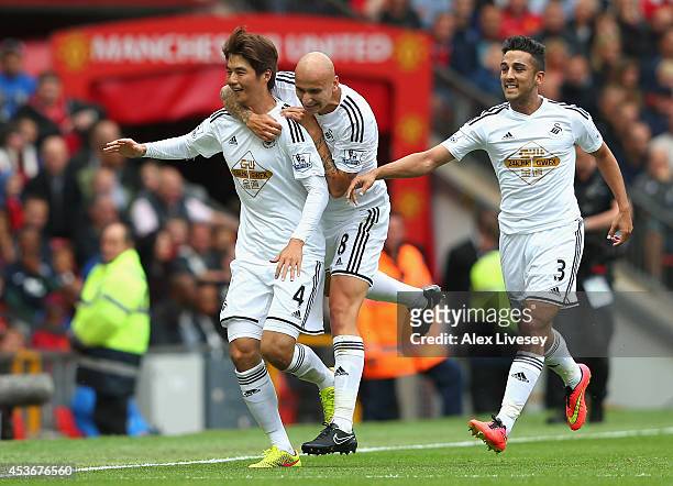 Ki Sung-Yeung of Swansea City celebrates scoring the opening goal with his team-mates Jonjo Shelvey and Neil Taylor during the Barclays Premier...