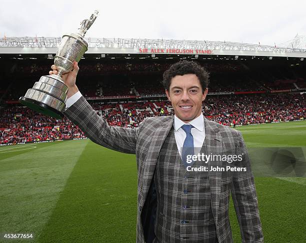 Golfer Rory McIlroy poses with the Open Golf Claret Jug trophy at halftime of the Premier League match between Manchester United and Swansea City at...