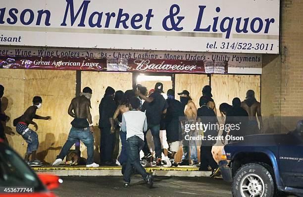 People loot the Ferguson Market and Liquor store on August 16, 2014 in Ferguson, Missouri. Several businesses were looted as police held their...