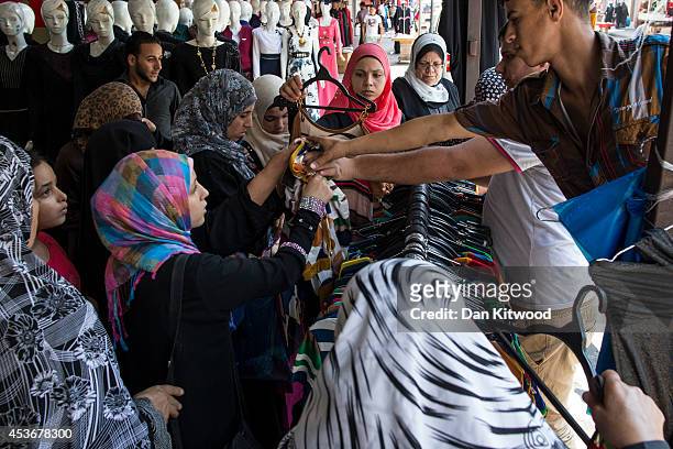 Women buy clothes on a market stall on August 16, 2014 in Gaza City, Gaza. A five-day ceasefire between Palestinian factions and Israel continues as...