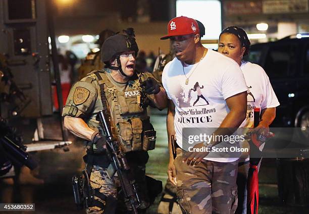 Police confront demonstrators during a protest over the shooting of Michael Brown on August 15, 2014 in Ferguson, Missouri. County police shot pepper...