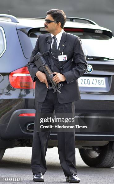 Special Protection Group official in suit with P90 gun stands
