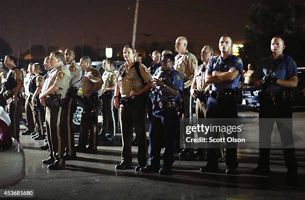 Police listen to taunts from demonstrators during a protest over the shooting of Michael Brown on August 15, 2014 in Ferguson, Missouri. Police shot...