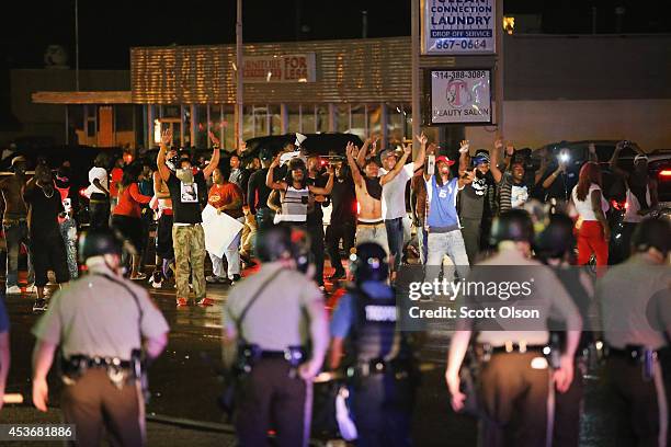 Demonstrators taunt police during a protest over the shooting death of Michael Williams on August 15, 2014 in Ferguson, Missouri, Police shot pepper...