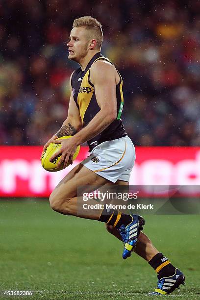 Brandon Ellis of the Tigers runs with the ball during the round 21 AFL match between the Adelaide Crows and the Richmond Tigers at Adelaide Oval on...