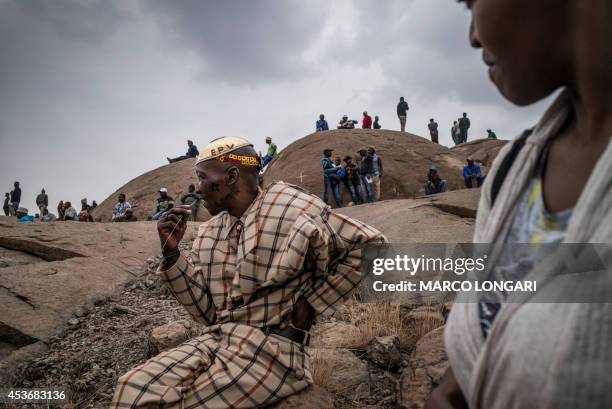 People gather on August 16, 2014 in front of the hill where two years ago miners where gunned down by the South African police during a violent wave...