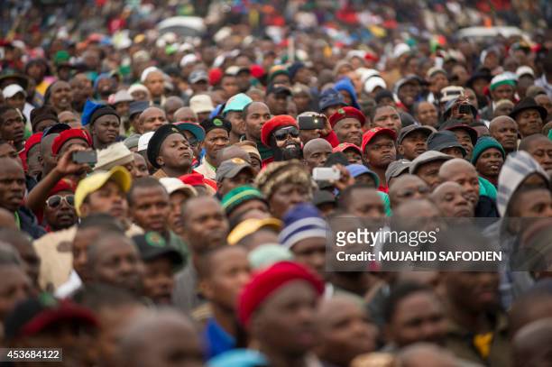 People gather on August 16, 2014 in Marikana, next to the hill where two years ago miners where gunned down by the South African police during a...