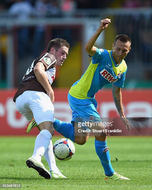 Adam Matuschyk of Cologne is challenged by Franke Dominik of Braunschweig during the DFB Pokal match between FT Braunschweig and 1. FC Koeln on...