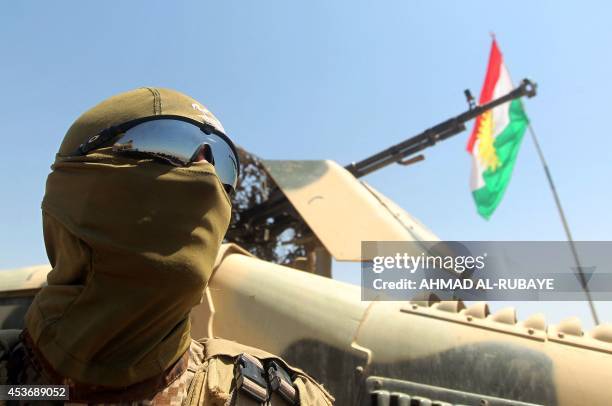 An Iraqi Kurdish Peshmerga fighter monitors the area from their front line position in Bashiqa, a town 13 kilometres north-east of Mosul on August...