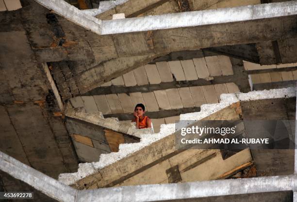 An Iraqi Yazidi boy, who fled his home when Islamic State militants attacked the town of Sinjar, looks down the staircase of a building under...