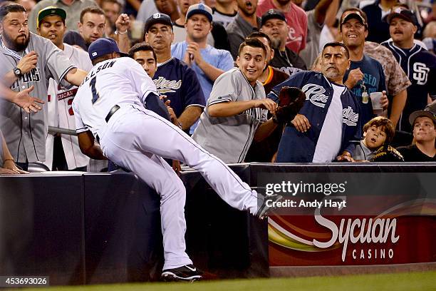 Chris Nelson of the San Diego Padres heads into the stands as he makes the catch on a foul ball hit by Charlie Blackmon of the Colorado Rockies...