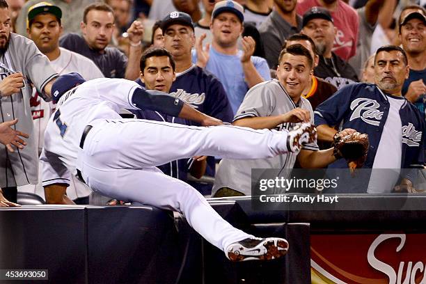 Chris Nelson of the San Diego Padres heads into the stands as he makes the catch on a foul ball hit by Charlie Blackmon of the Colorado Rockies...