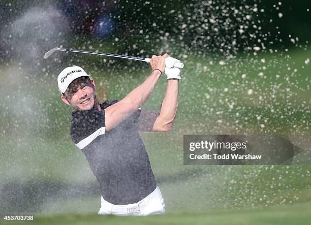 Camilo Villegas of Colombia plays a shot from the bunker on the 18th hole during the third round of the Wyndham Championship at Sedgefield Country...