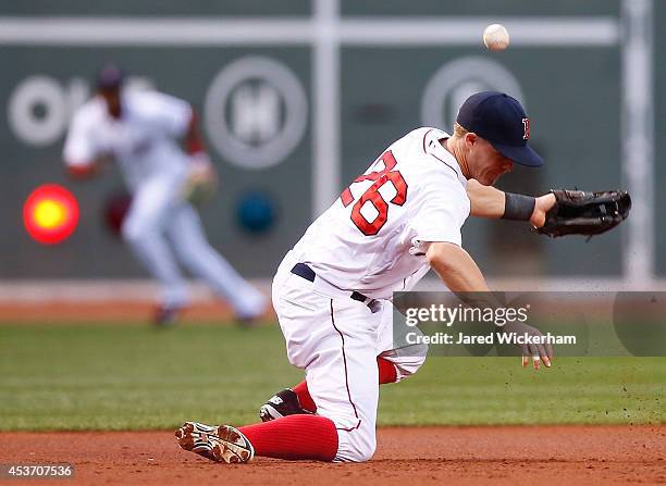 Brock Holt of the Boston Red Sox misplays a ground ball at third base in the first inning against the Houston Astros during the game at Fenway Park...