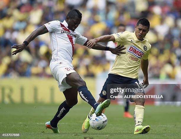 Osvaldo Martinez of America vies for the ball with Duvier Riascos of Morelia during their Apertura 2014 Mexican tournament football match at the...