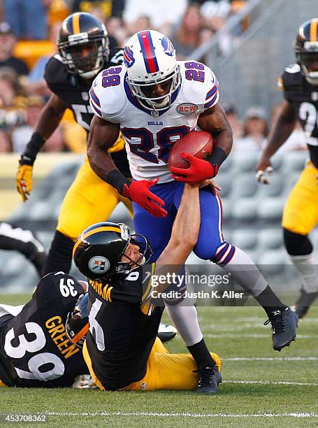 Spiller of the Buffalo Bills is dragged down by Shaun Suisham of the Pittsburgh Steelers after his kickoff return during the first quarter at Heinz...