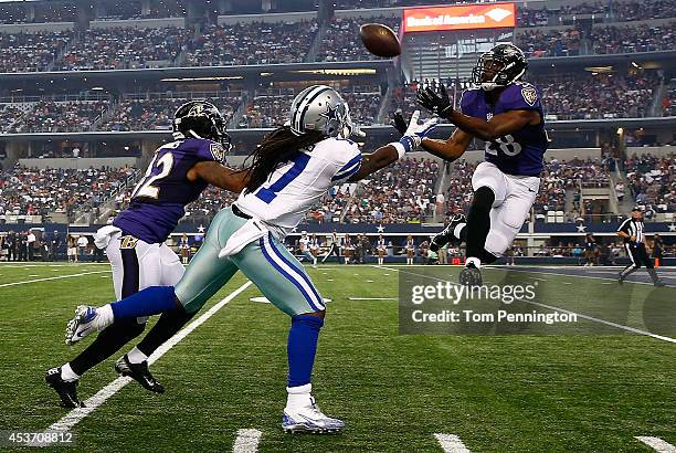 Brynden Trawick of the Baltimore Ravens intercepts a pass intended for Dwayne Harris of the Dallas Cowboys in the first half of their preseason game...