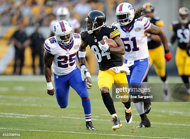 Antonio Brown of the Pittsburgh Steelers runs for a touchdown in front of Da'Norris Searcy and Brandon Spikes of the Buffalo Bills during the first...