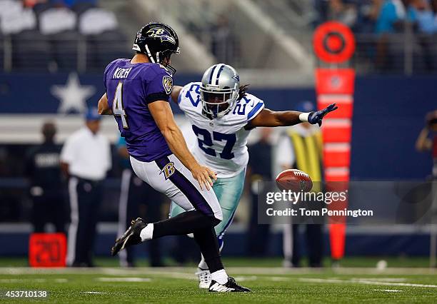 Sam Koch of the Baltimore Ravens punts as J.J. Wilcox of the Dallas Cowboys applies pressure in the first half of their preseason game at AT&T...