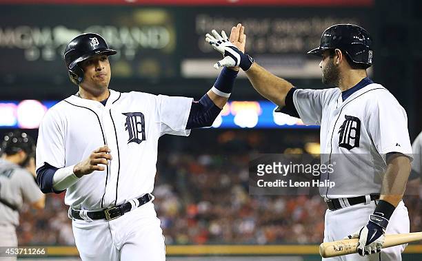 Victor Martinez of the Detroit Tgers celebrates with teammate Alex Avila after scoring on the Nick Castellanos single to center field during the...