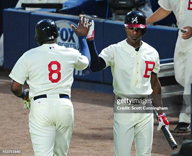 Justin Upton of the Atlanta Braves is congratulated by B. J. Upton after scoring a fourth inning run against the Oakland Athletics at Turner Field on...