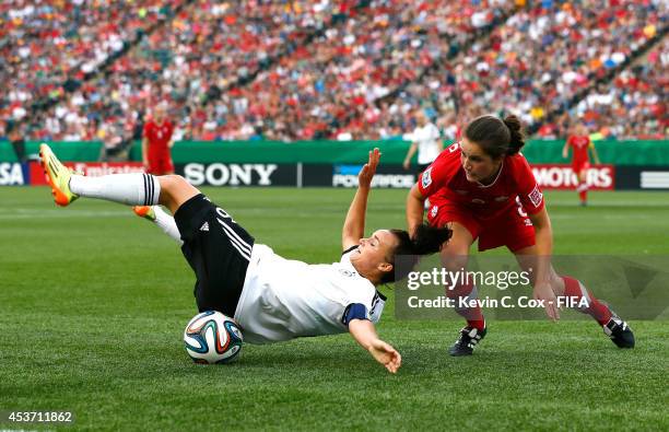 Lina Magull of Germany falls on the ball as she is challenged by Jessie Fleming of Canada during the FIFA U-20 Women's World Cup Canada 2014 Quarter...